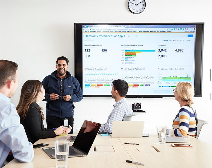 Person presenting to group at table