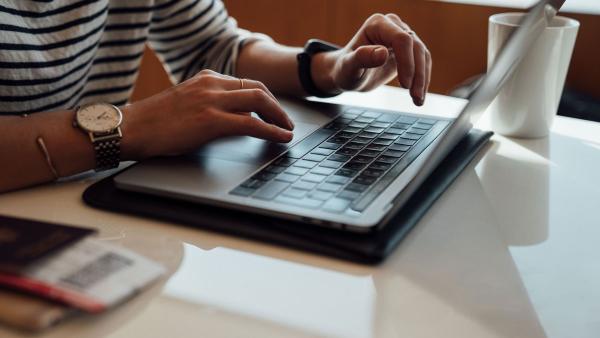 Hands typing on laptop