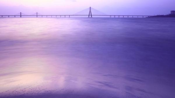 Large body of water with a bridge in the background