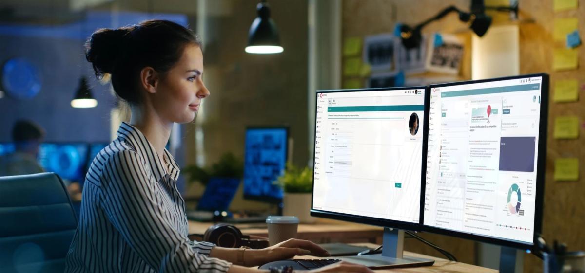 Woman sits in front of The Access Group dashboards.